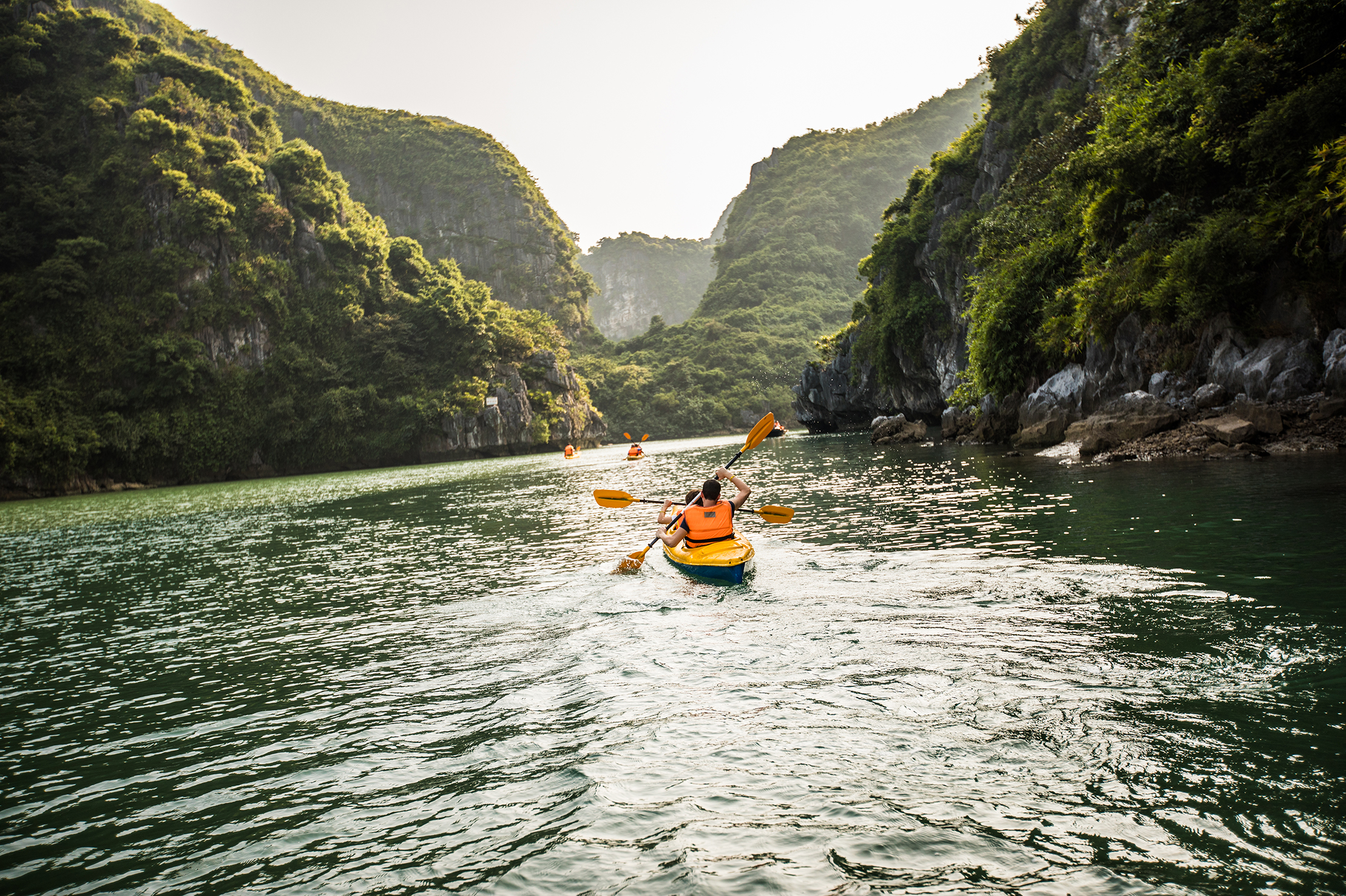 Tourist kayaking between limestone karsts in Ha Long Bay